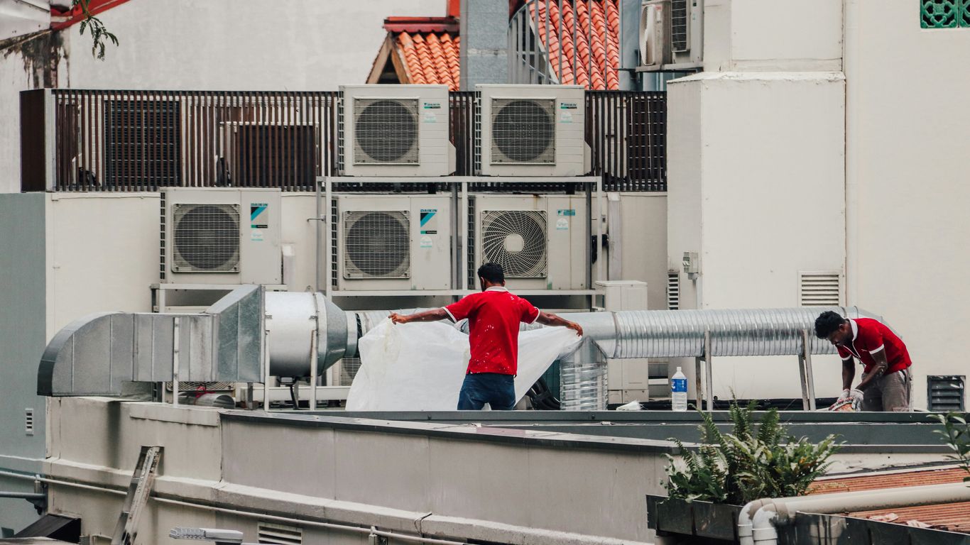 a couple of men standing on top of a roof