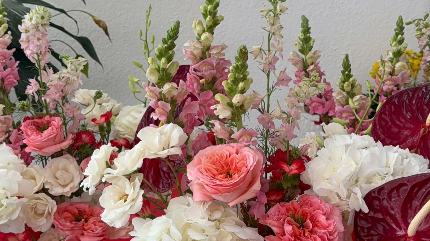 A vibrant floral arrangement with pink and white flowers, accented by red.