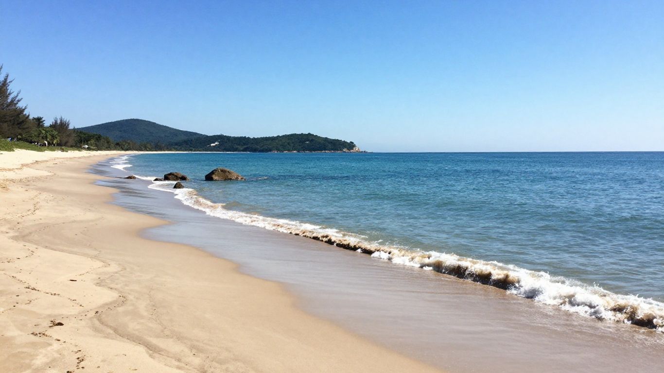 Beach with blue water and green hills