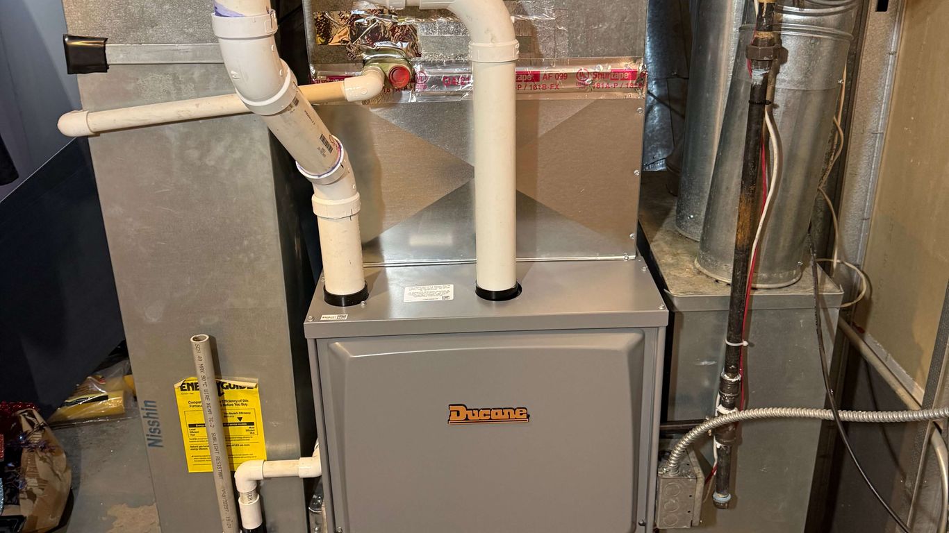A furnace and air handler with PVC pipes and metal ductwork.