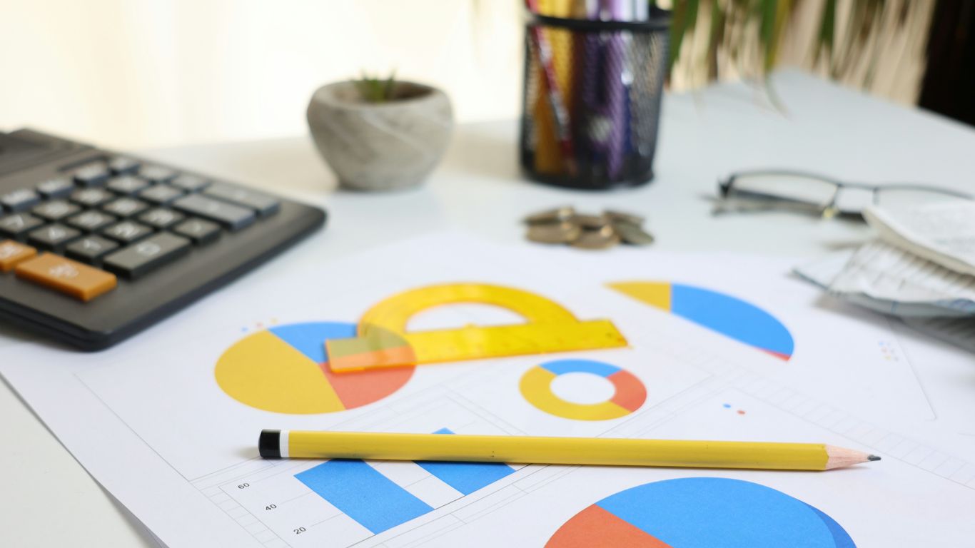 Desk with calculator, charts, and pencil
