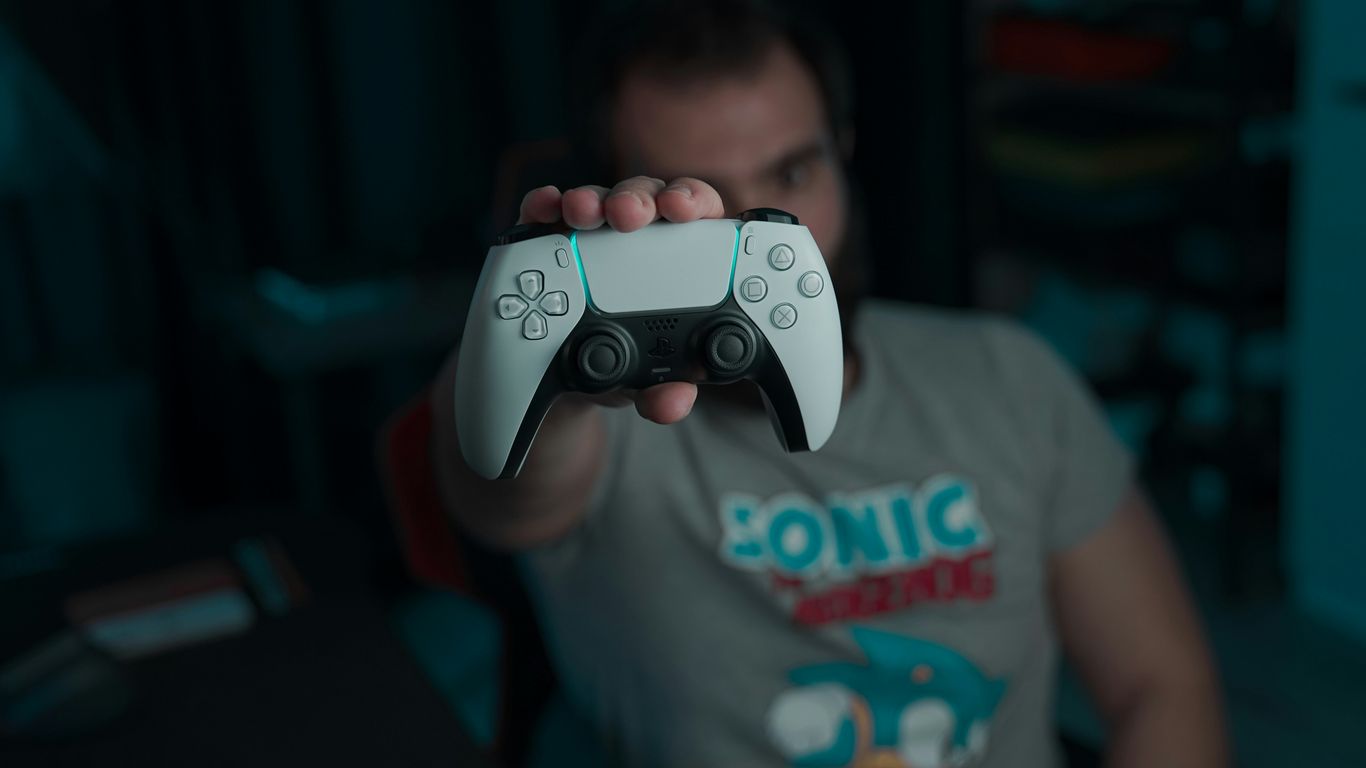 boy in gray and red crew neck t-shirt holding gray game controller