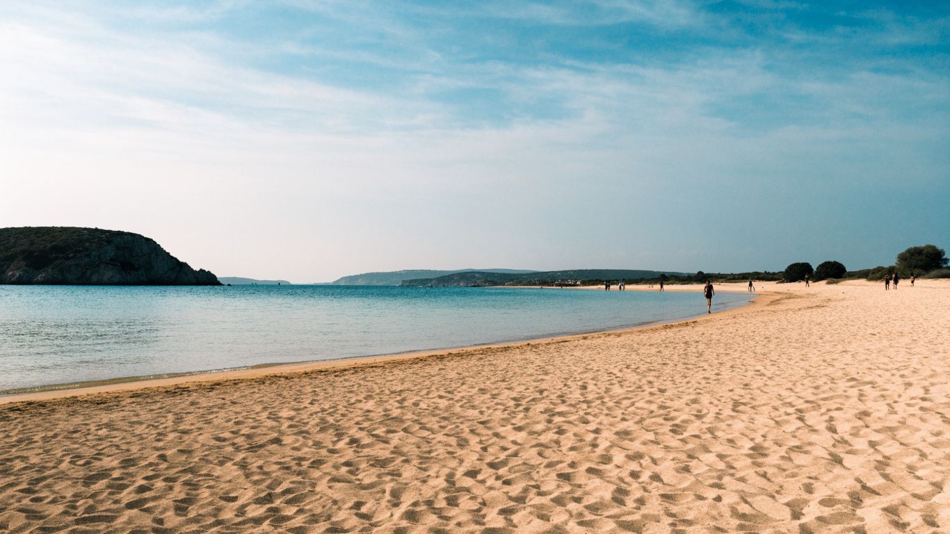 Naturist beach with pale sand and calm blue water