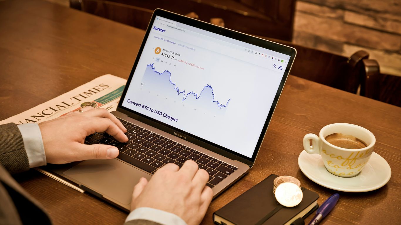 a person using a laptop on a wooden table