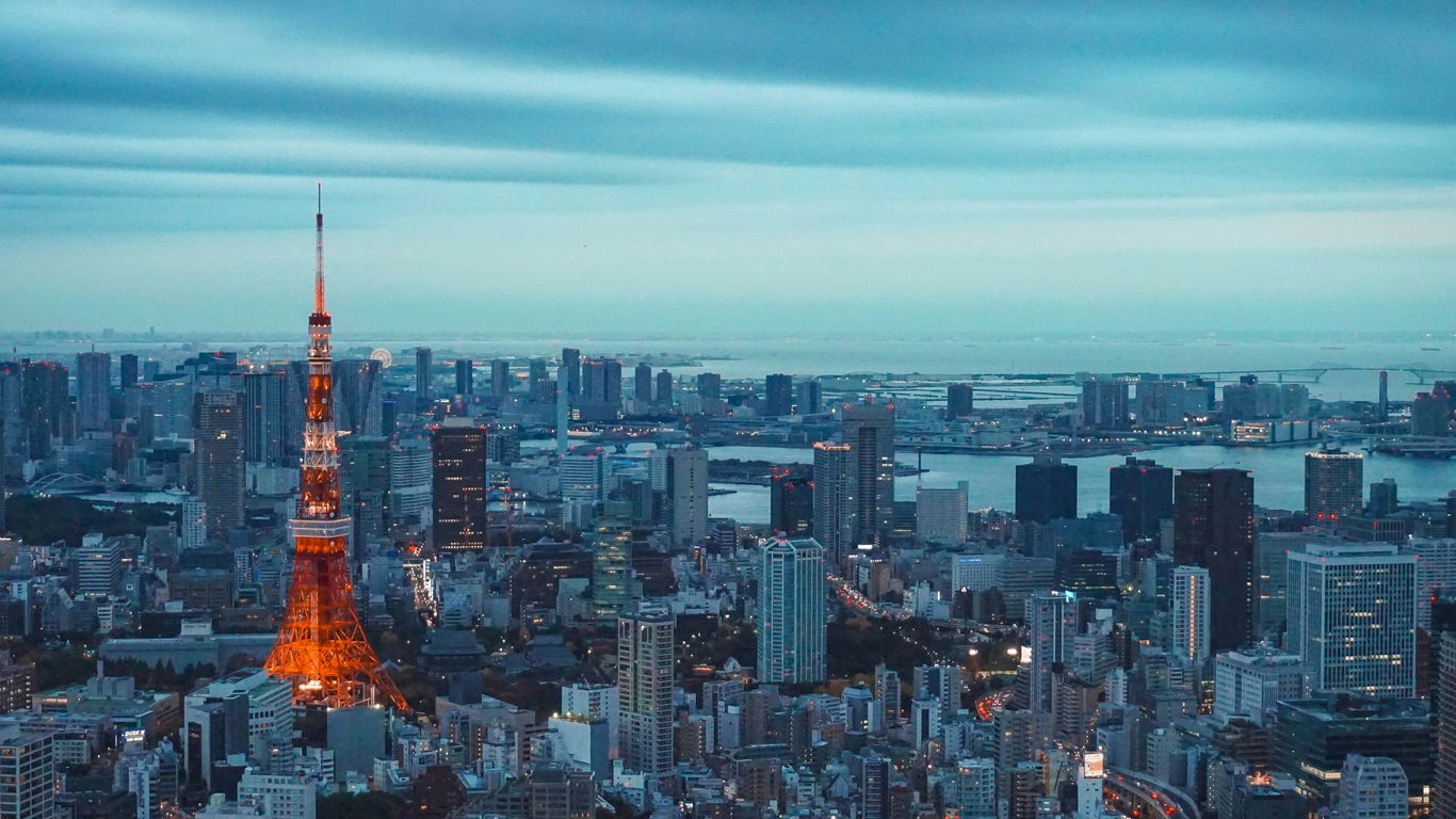 tokyo tower illuminated at dusk with city skyline