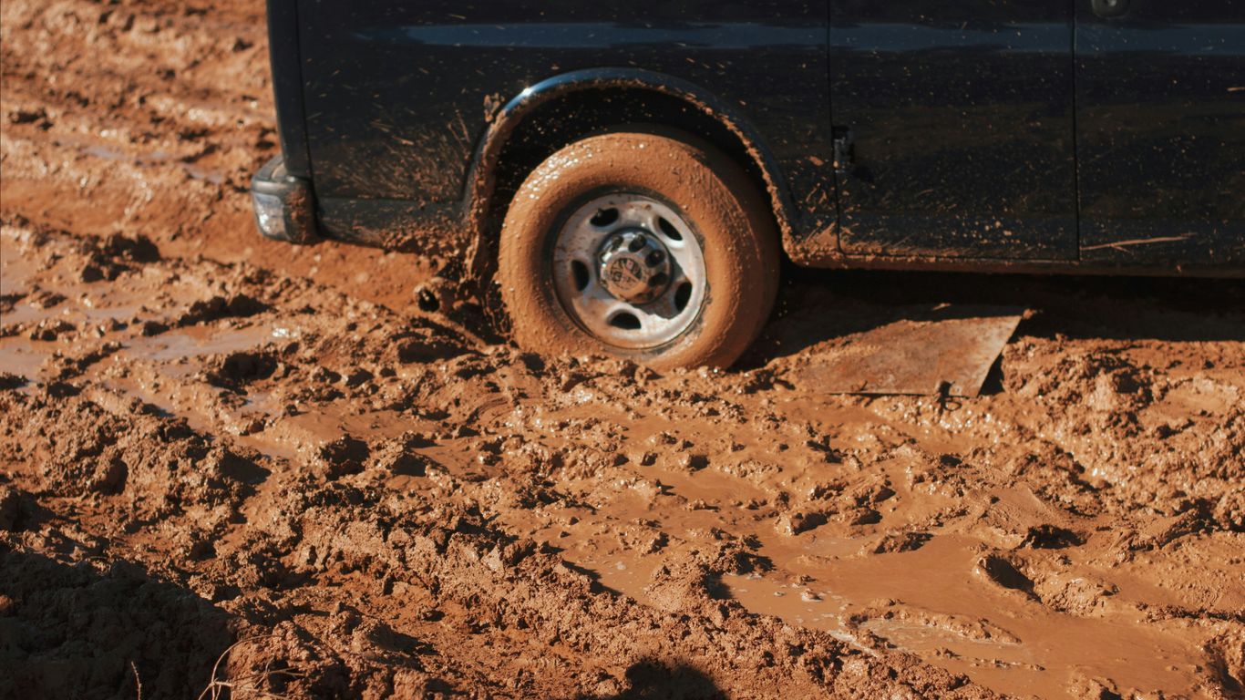 black car stuck on mud