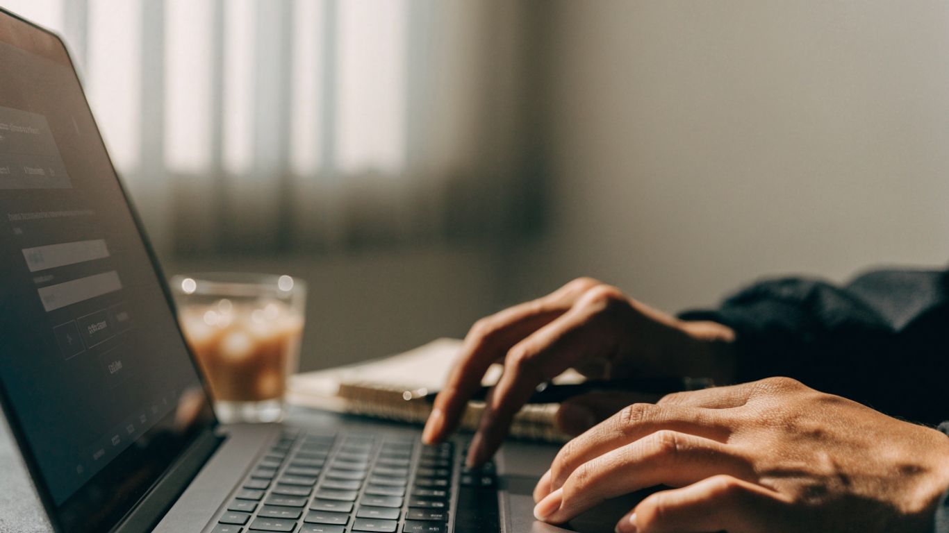 Hands checking a payout request on a laptop