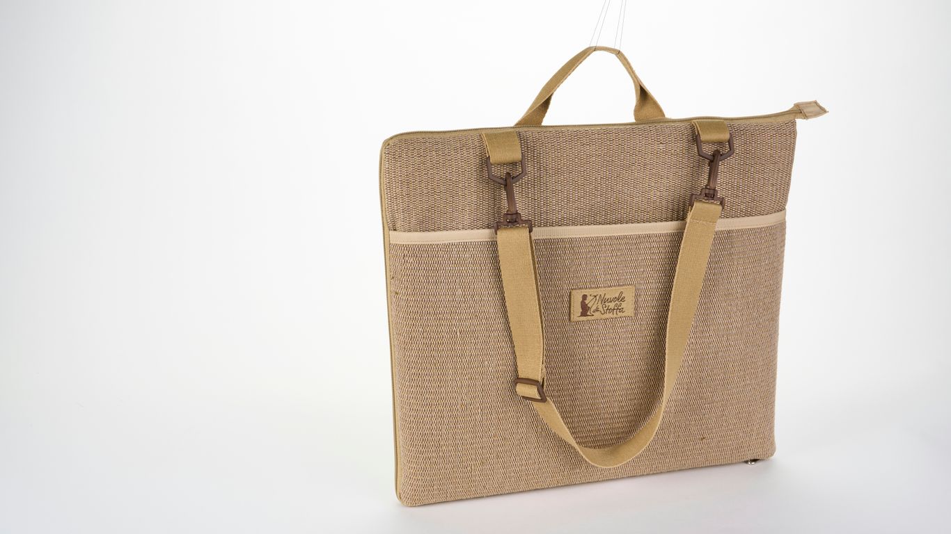 Compact yoga mat beside travel bag