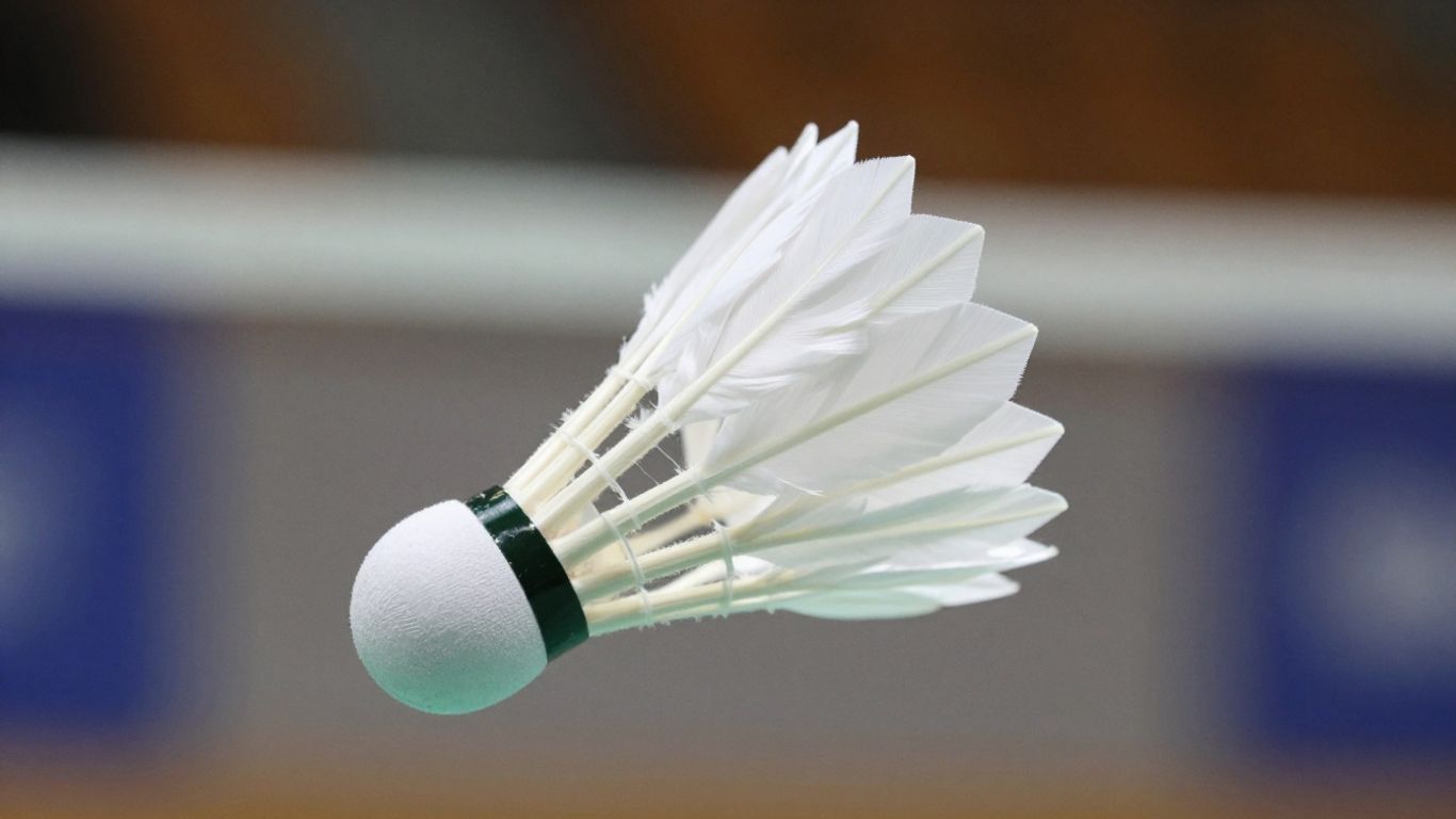 Feather badminton shuttlecock in flight during a game.