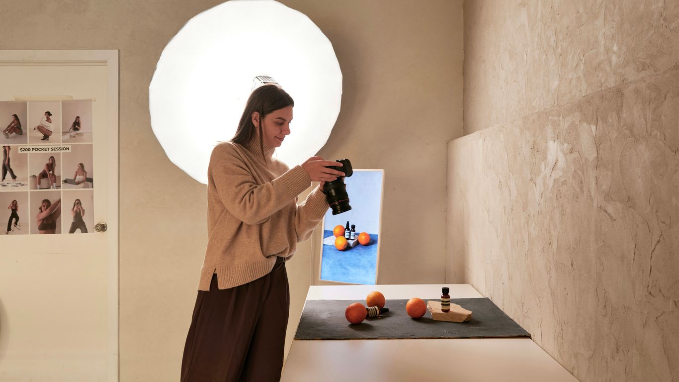 A woman standing in front of a table with a bottle of wine