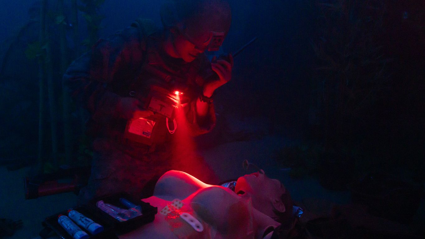 Man shines red light on unconscious woman.