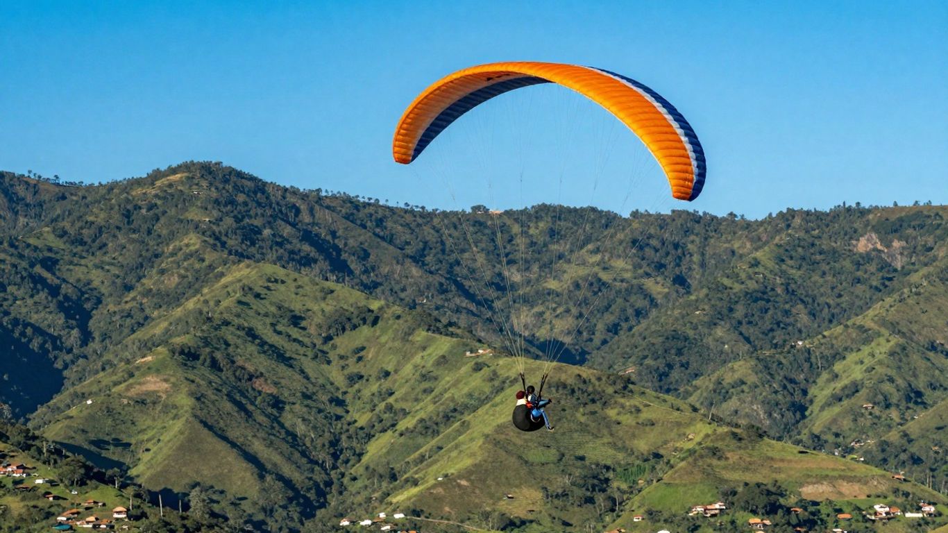 Paraglider flying over green mountains near Medellin.