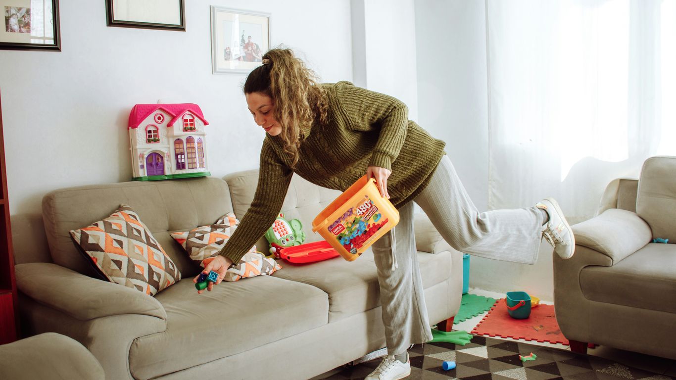 a person holding a box and a child on a couch