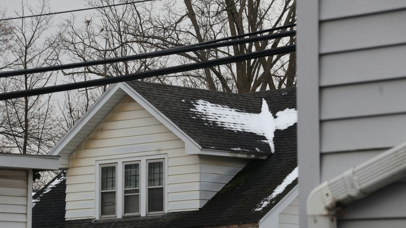 A white house with snow on its roof.