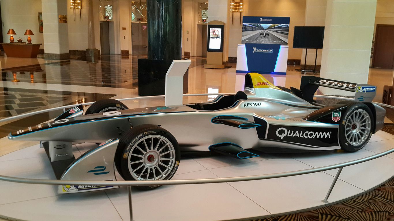 A sleek silver formula e race car on display