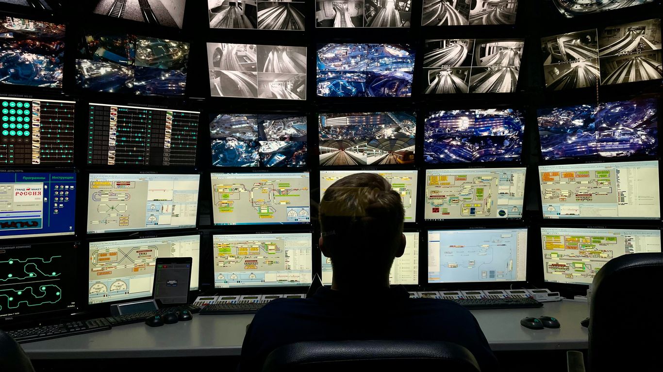 a man sitting in front of multiple monitors