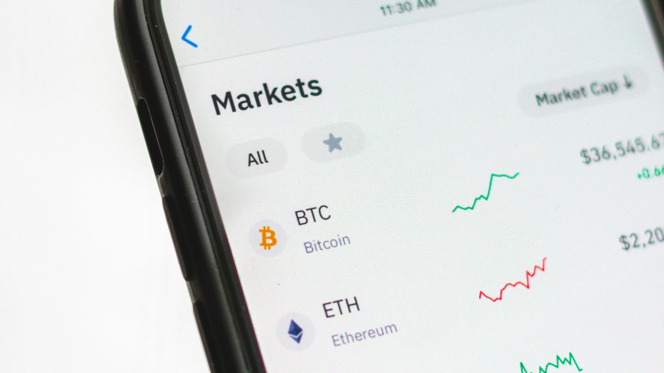 Smartphone displaying cryptocurrency market values and fluctuations.