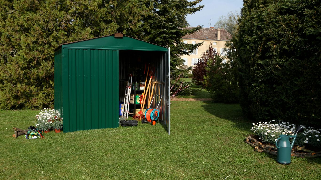 half opened green shed on grass near trees