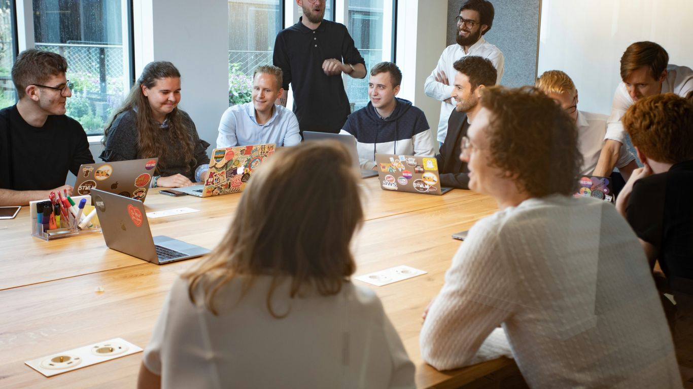 a group of people sitting around a wooden table
