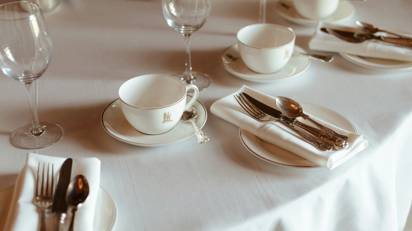 a table set with silverware and wine glasses