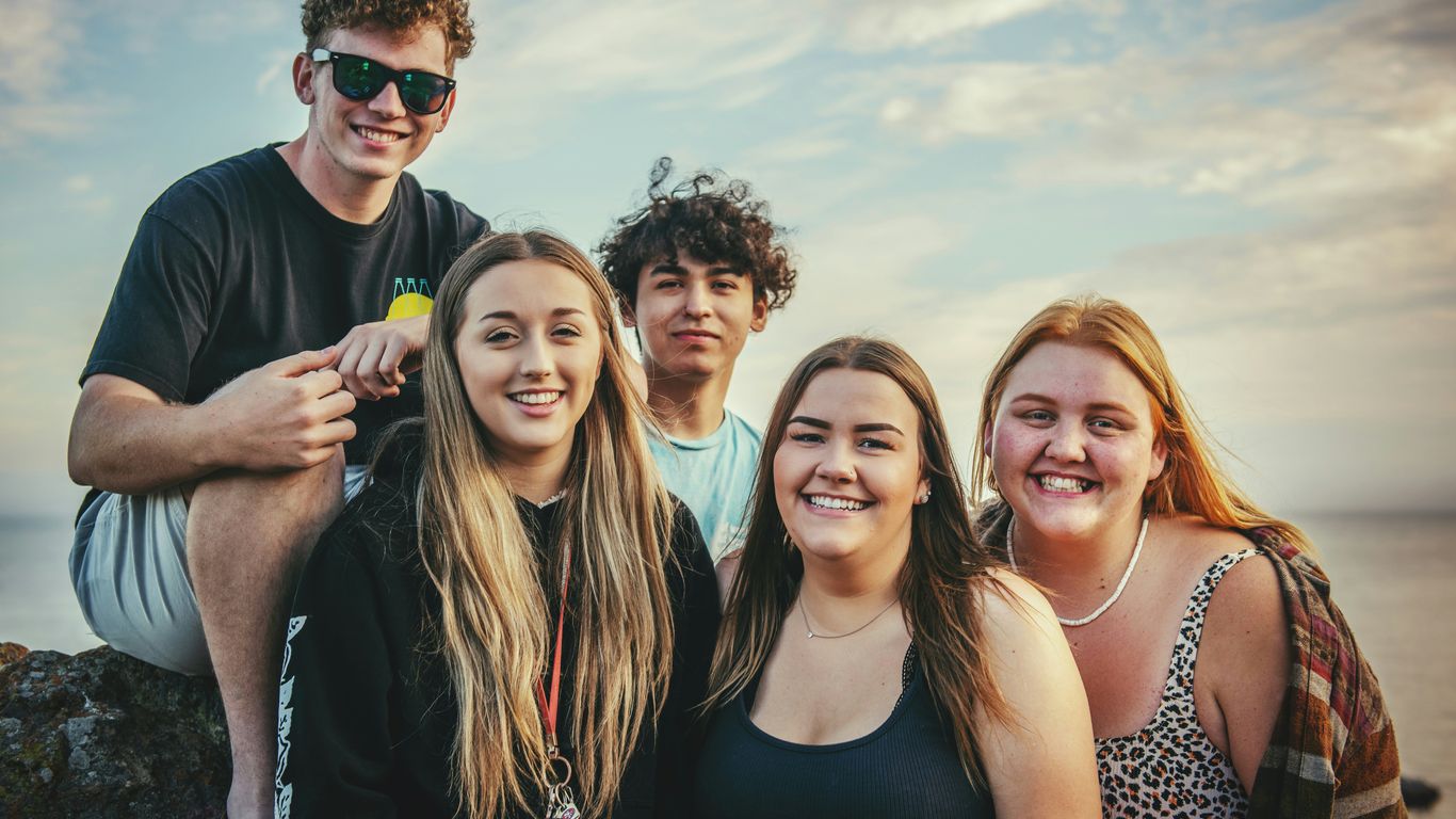 A group of teenagers using mobile devices together