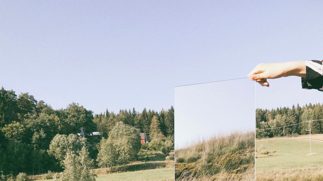 person holding mirror during daytime