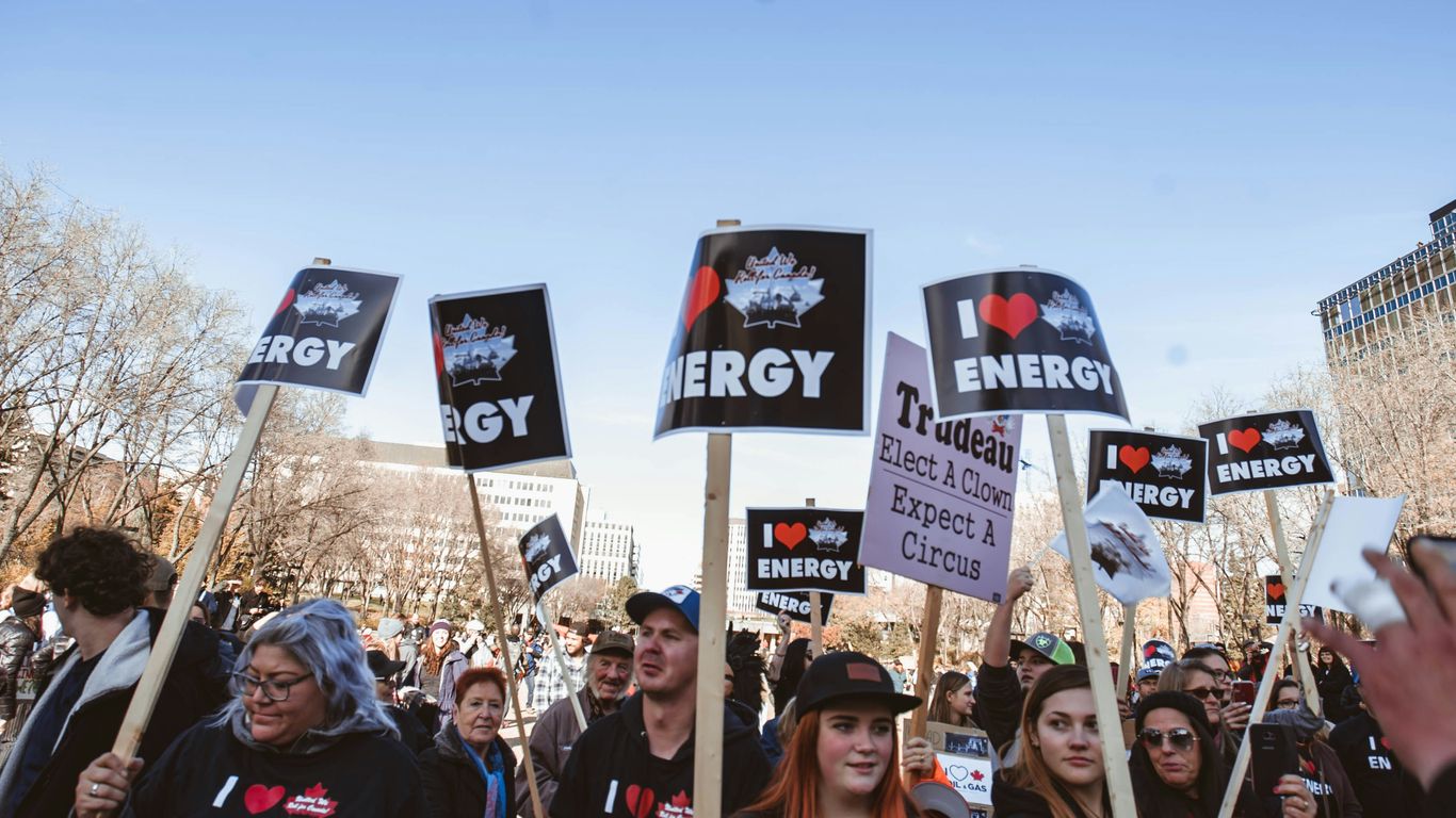 crowd holding black I Heart Energy signs