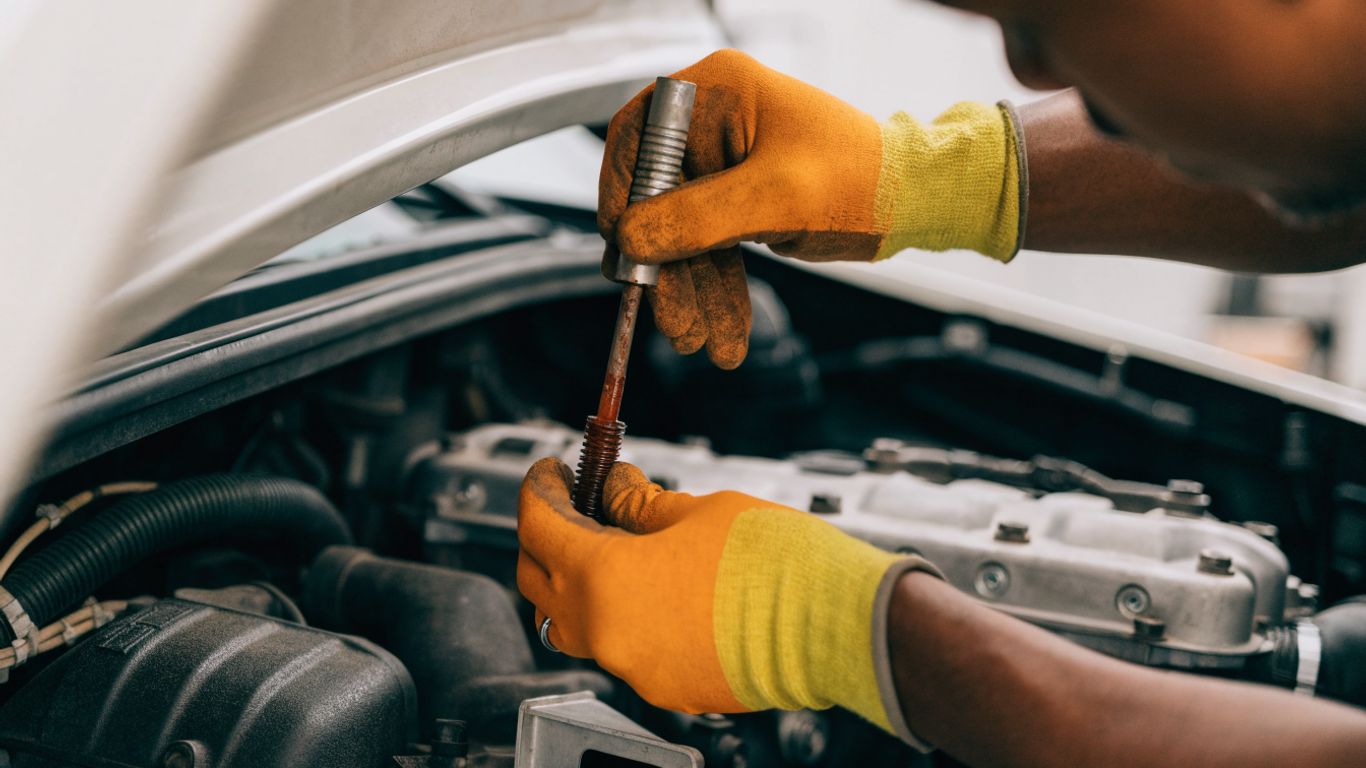 A mechanic checking a car transmission fluid level