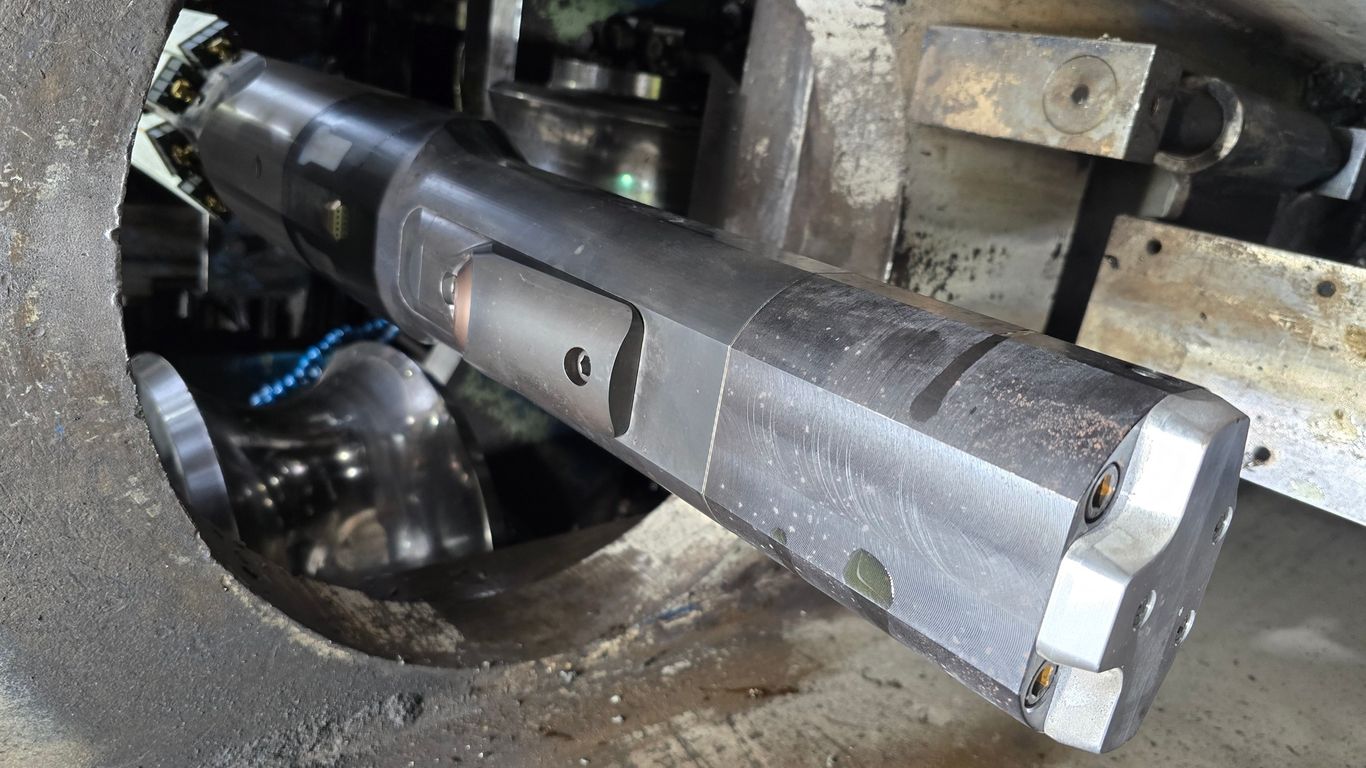 Close-up of a metal cutting tool inside industrial machinery.