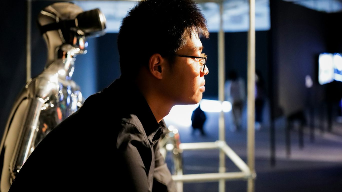 a man sitting in front of a bike in a room