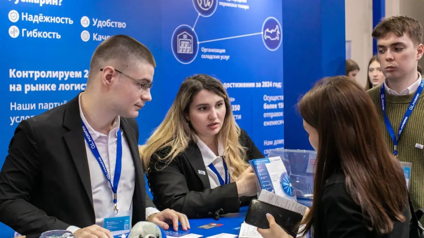 People at a business exhibition interacting with a booth.