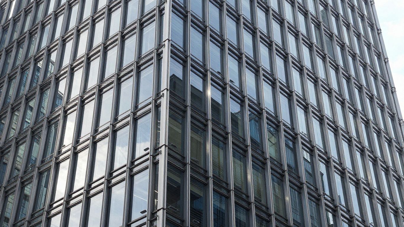 Modern building with glass curtain wall and metallic framing.
