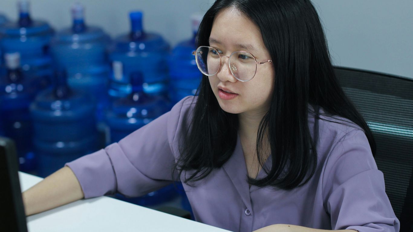 a woman sitting at a desk with a laptop