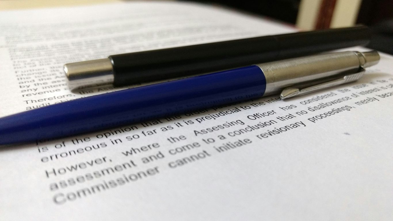 two black and blue click pens on white book page