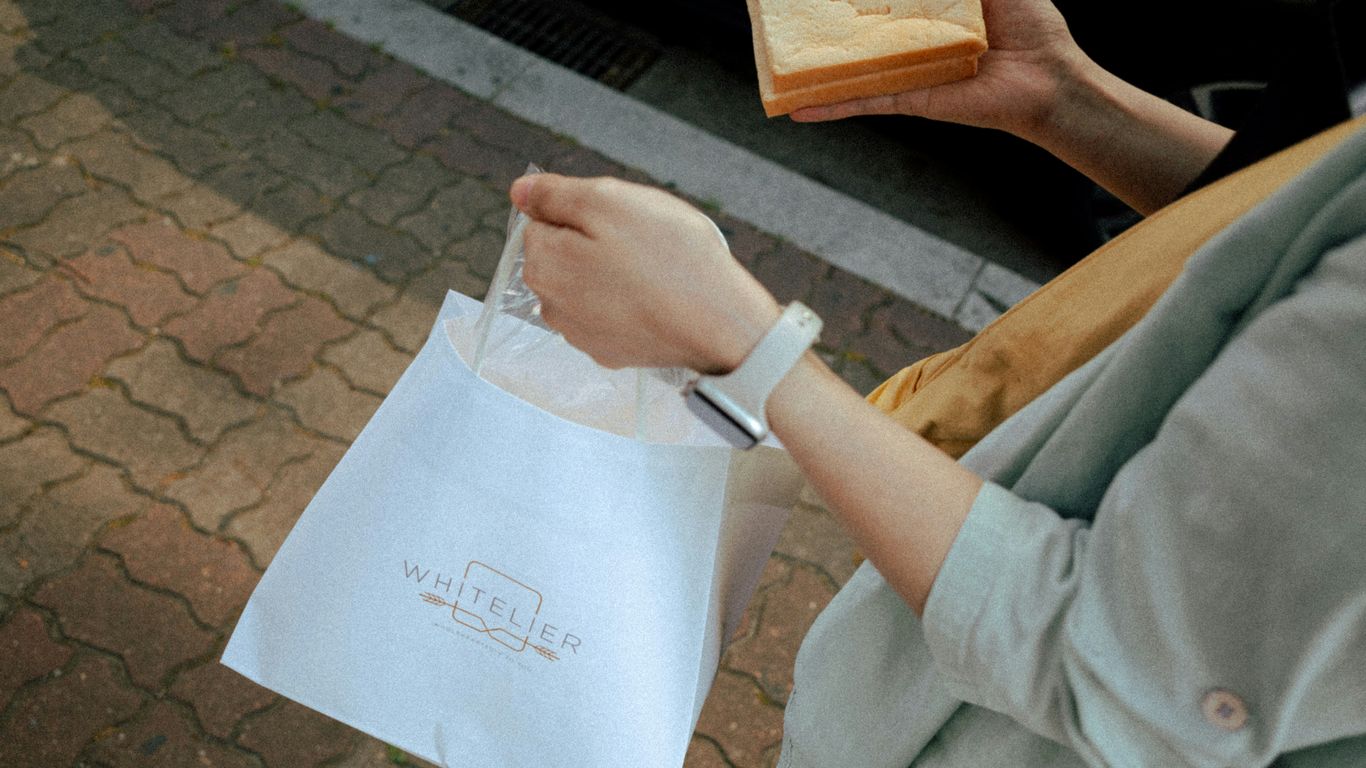 Someone is holding a bag and bread.