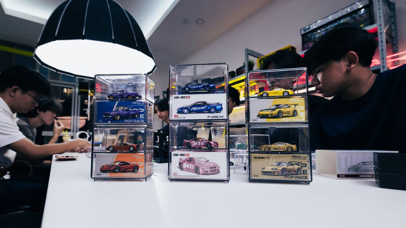 People at a counter with display cases