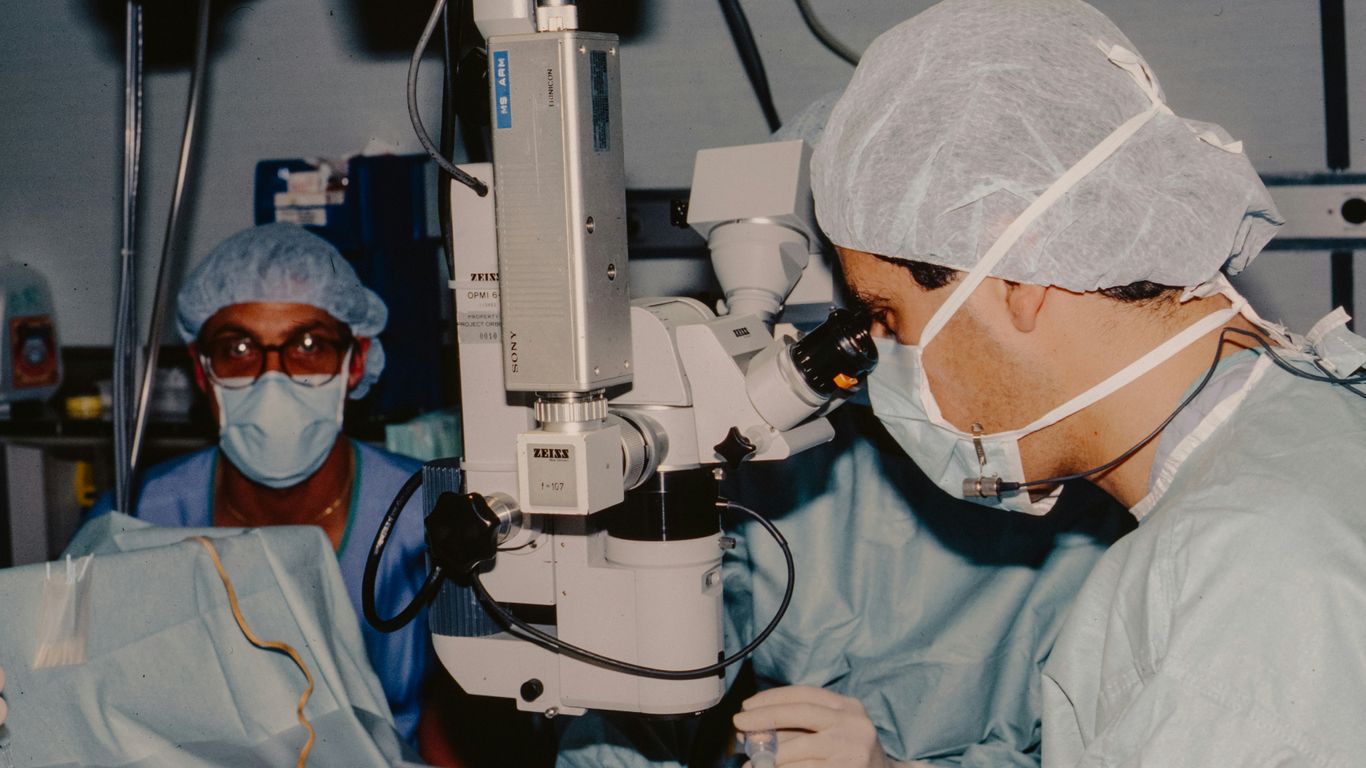 Surgeons operating with a microscope
