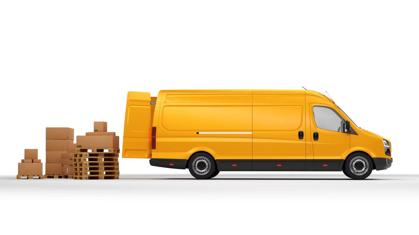 A yellow delivery van with its back doors open, next to stacked boxes on pallets.