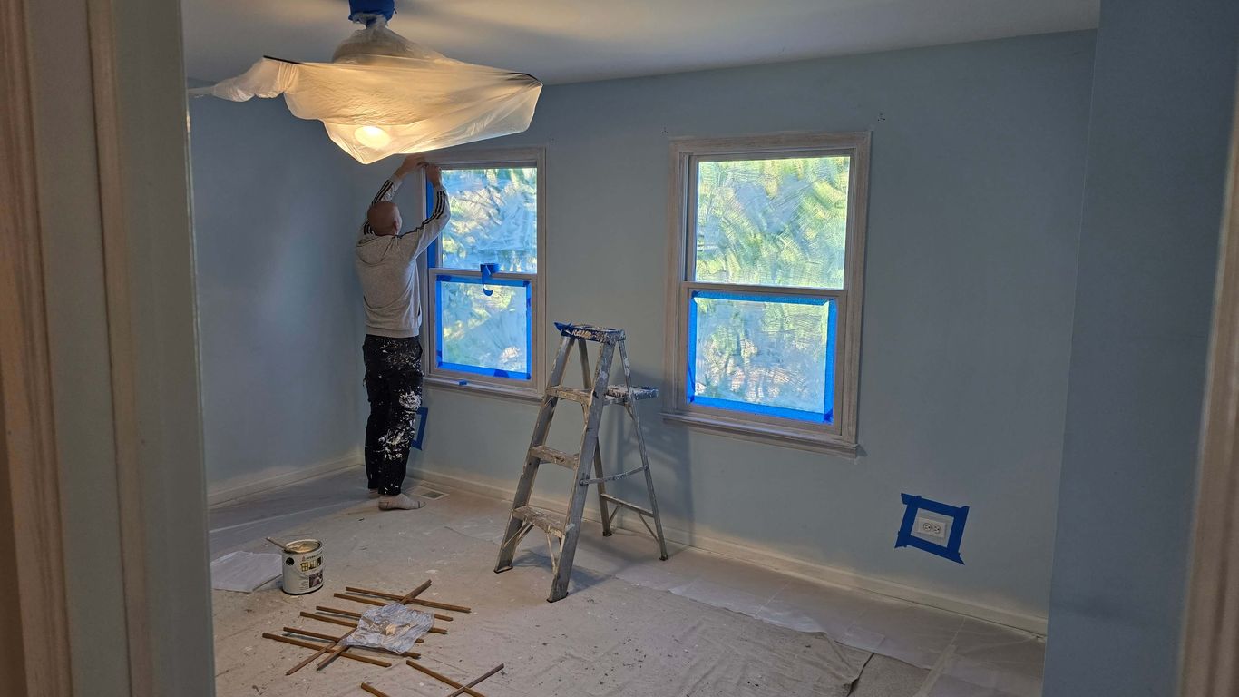 Room being prepped for painting with drop cloths and tape.