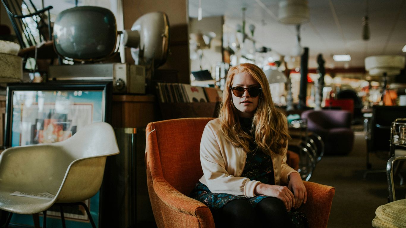 woman sitting on sofa wearing sunglasses