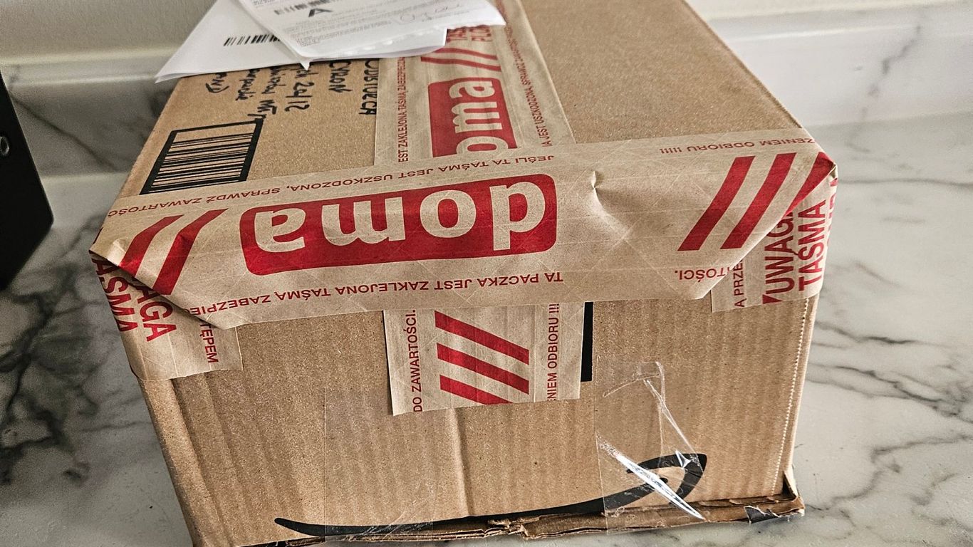 A cardboard box with red and white warning tape, and a shipping label.