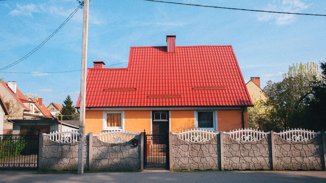 A house with an orange wall and red roof.