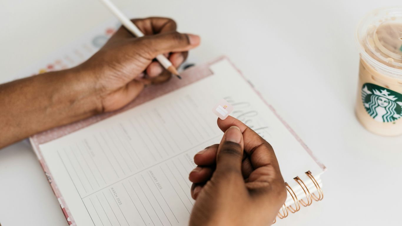 person about to write on notebook