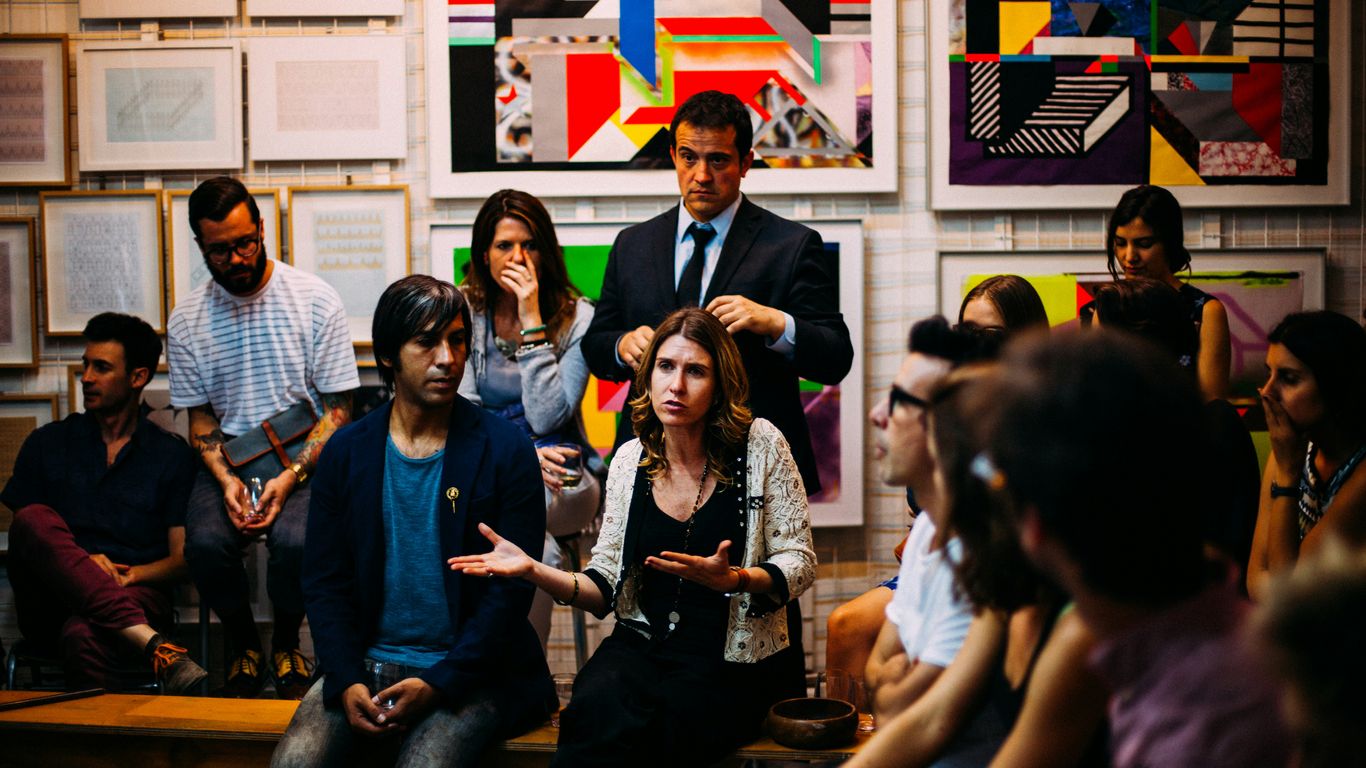 A diverse group gathered in a community space to discuss insurance model structures