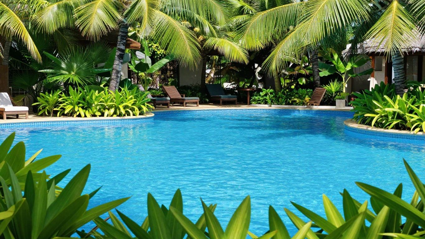 Oaks Port Douglas Resort pool with palm trees and blue water.