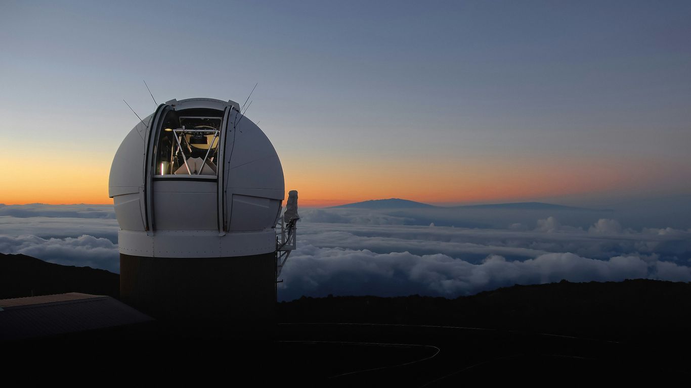 a telescope sitting on top of a mountain above the clouds
