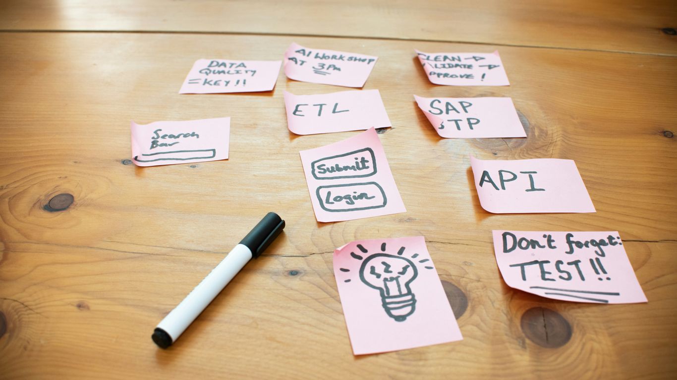 Sticky notes with words and drawings on wooden table.
