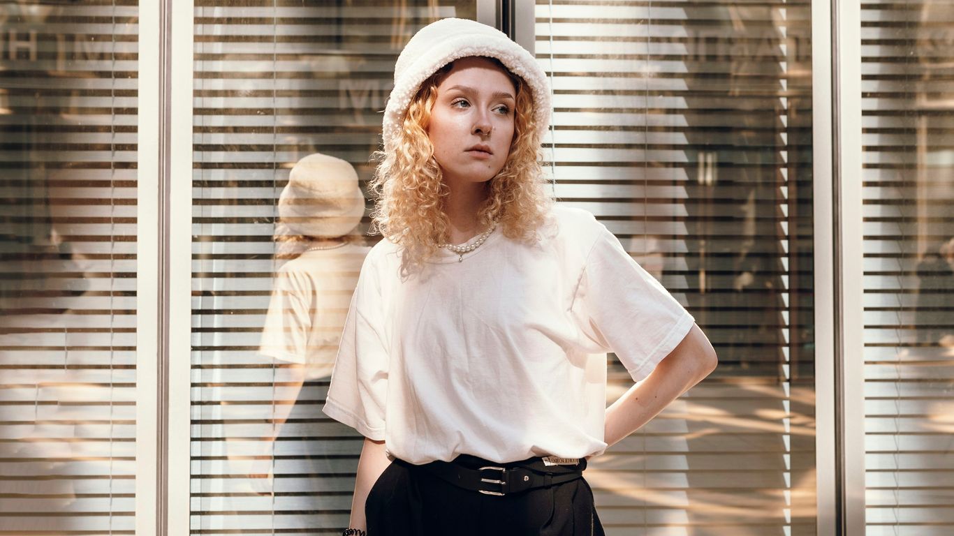 a woman standing in front of a window with her hands on her hips