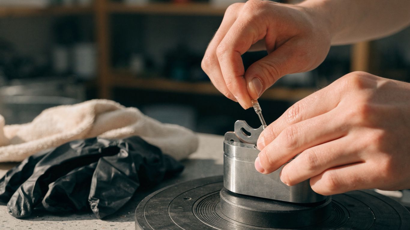 Hands applying a small amount of lubricant to a clean component