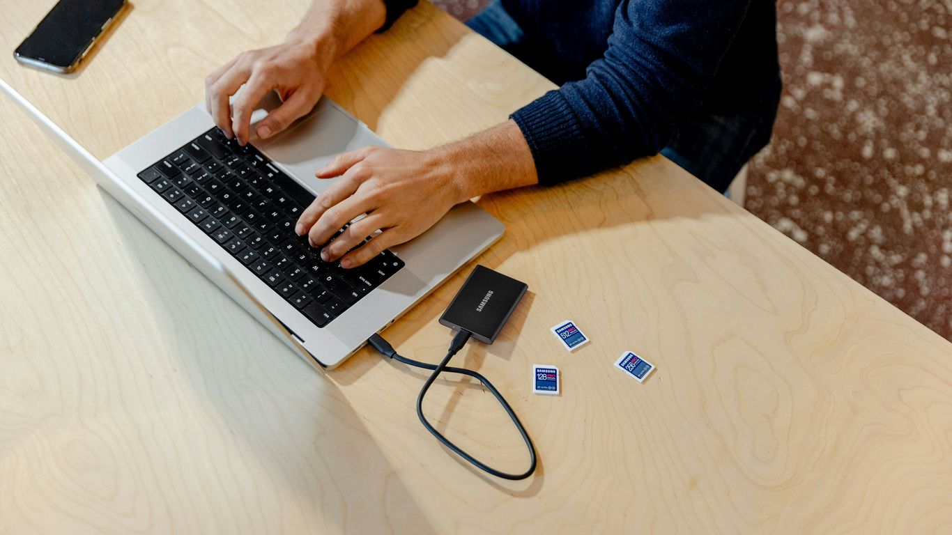 A person sitting at a table using a laptop computer